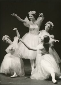 A black-and-white photo of four ballet dancers in white