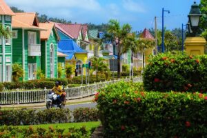 Colorful houses lining a well-kept street with palm trees and bushes