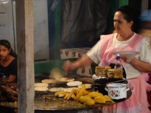 A woman cooking round flatbreads on a large round table