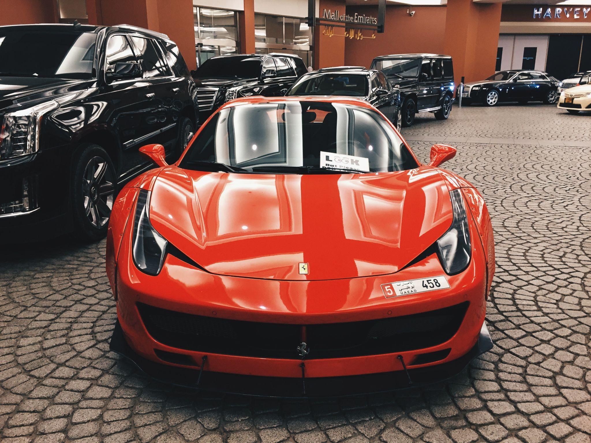 picture of a red ferrari with other cars in the background.