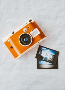 Orange camera with pictures laying next to it