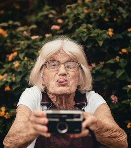 Older white woman takes a picture with a DSLR camera