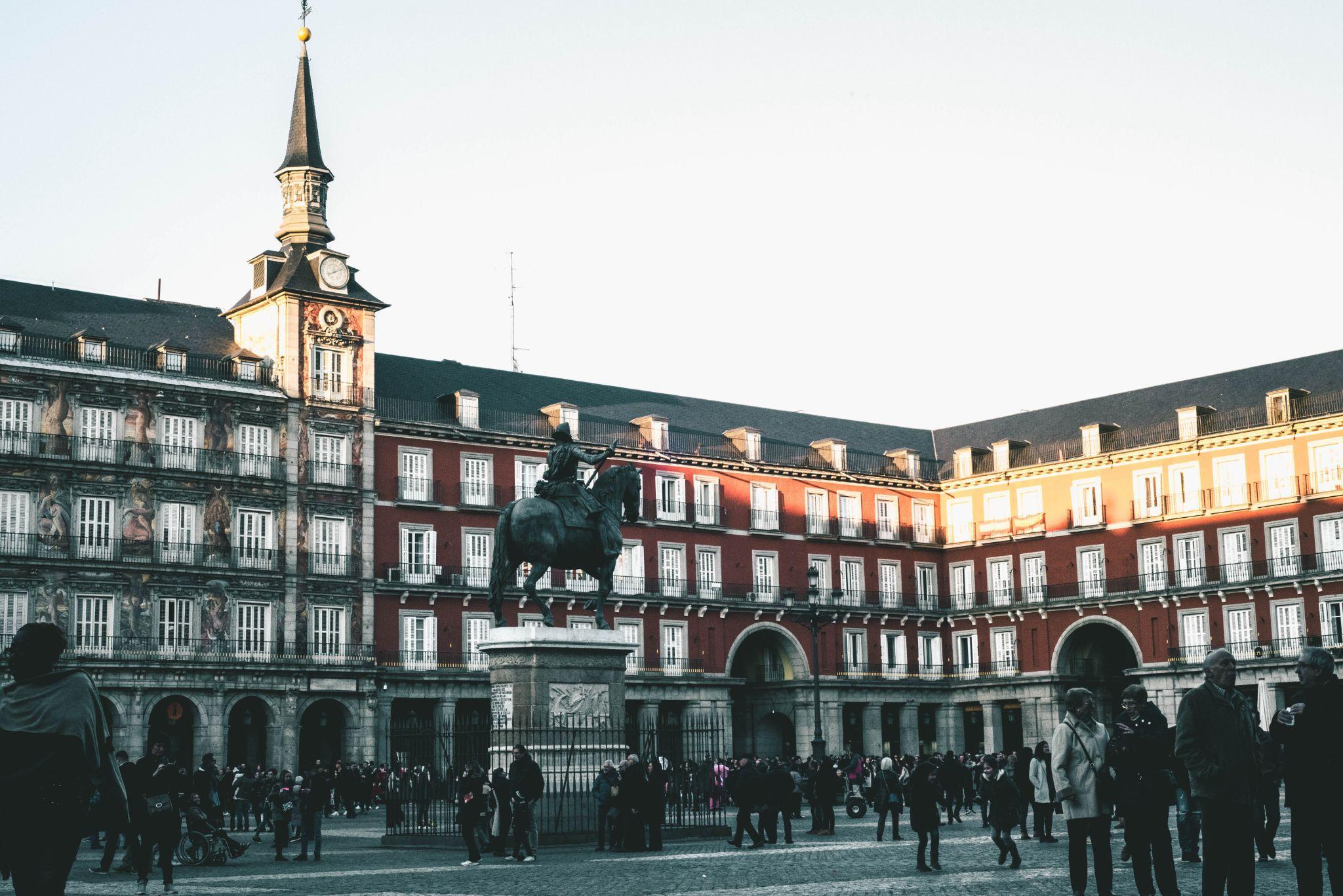 Photo of a plaza with a statue of a horse and rider outside the main building with many windows