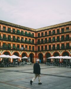 Photo of man walking in a plaza