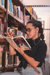 Photo of girl reading a book in the library.