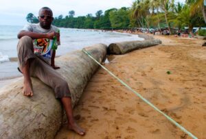 A man sitting on a log at the beach at Arena Blanca