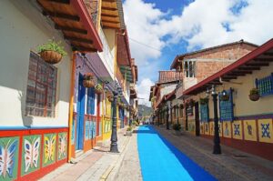 Colorful shops on a street with a wide bright blue stripe painted down the center