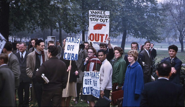 A photo of protestors in a park holding signs