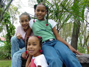 Three girls smiling for a picture in a park