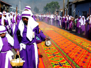 A parade of people clad in purple and white robes
