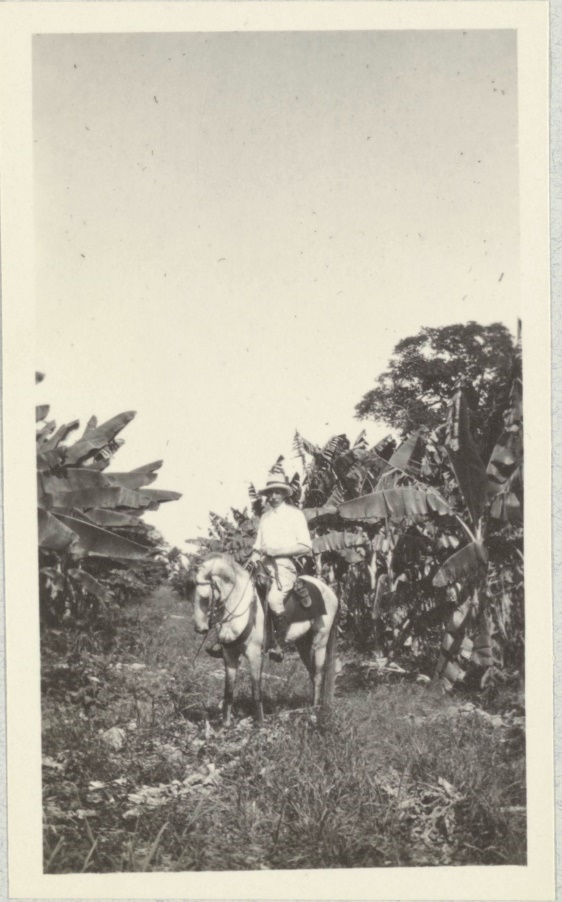 A black-and-white photograph of a man on a horse