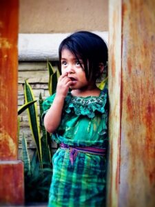 A small child dressed in colorful Honduran clothes