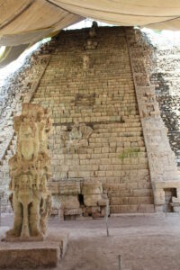 An ancient Mayan staircase with carved statues.
