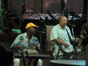 A man playing banjo and a man playing a drum