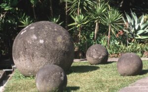A collection of large stone balls of various sizes on the grass