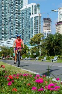 A person wearing a helmet riding a bike down a paved path.