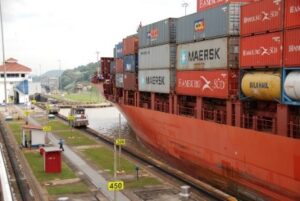A ship piled high with shipping containers in the Panama Canal