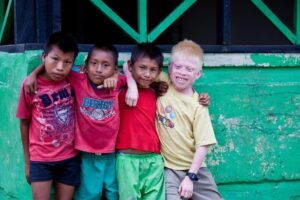 Four kuna children standing together with their arms around each other.