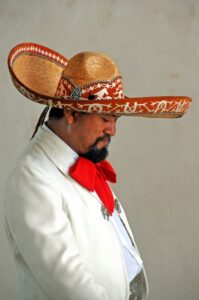 A man in a sombrero wearing a white suit