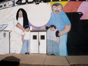 A mural of a family embracing a doorway of a building