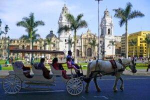 People riding in a horse-drawn carriage in the Plaza de Armas