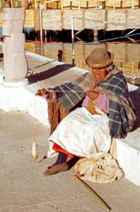 A woman spinning yarn outside
