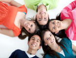 A group of people lying on the ground smiling.
