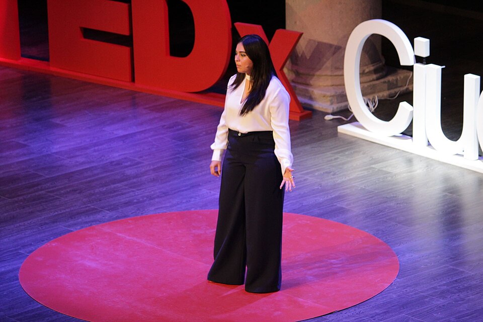 woman delivering a speech on the Tedx stage