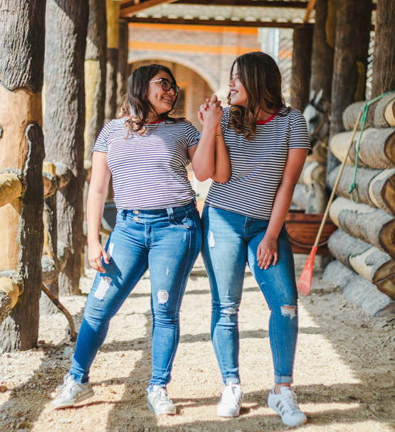 Two women dressed the same and looking at each other