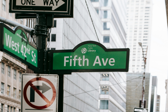 Photograph of two roadsides that say Fifth Avenue and West 42nd Stret