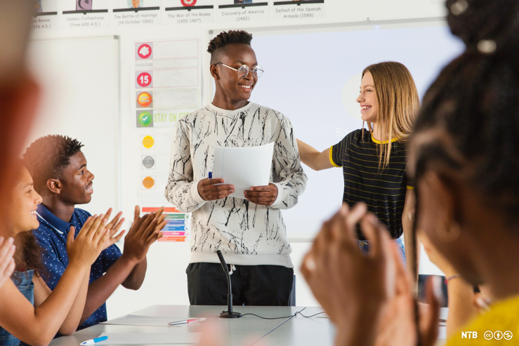 young student being applauded by his peers