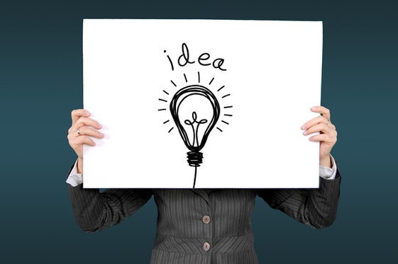 Person holding a sign that has a lightbulb and the word "idea" on it
