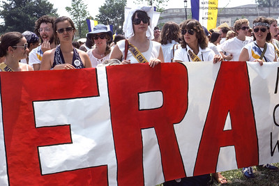 Protesters hold a large sign that says, "ERA"