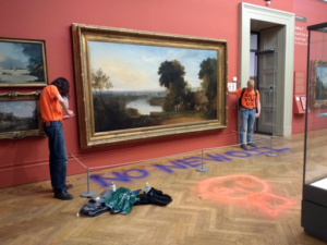 Two protesters stand next to a painting in a museum. "No New Oil" is spraypainted on the floor.